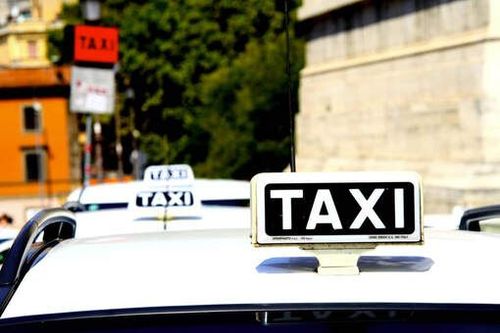 Taxi officiel blanc de Rome avec le logo du Comune di Roma et un taximètre visible
